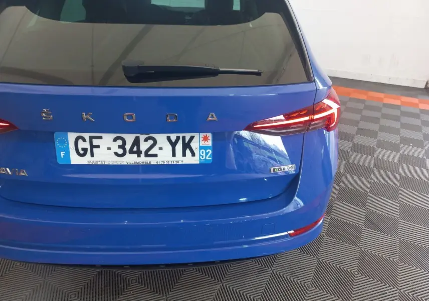 Vue arrière d'une Skoda Octavia bleu avec plaque française et badge e-TEC sur un sol à motifs géométriques.