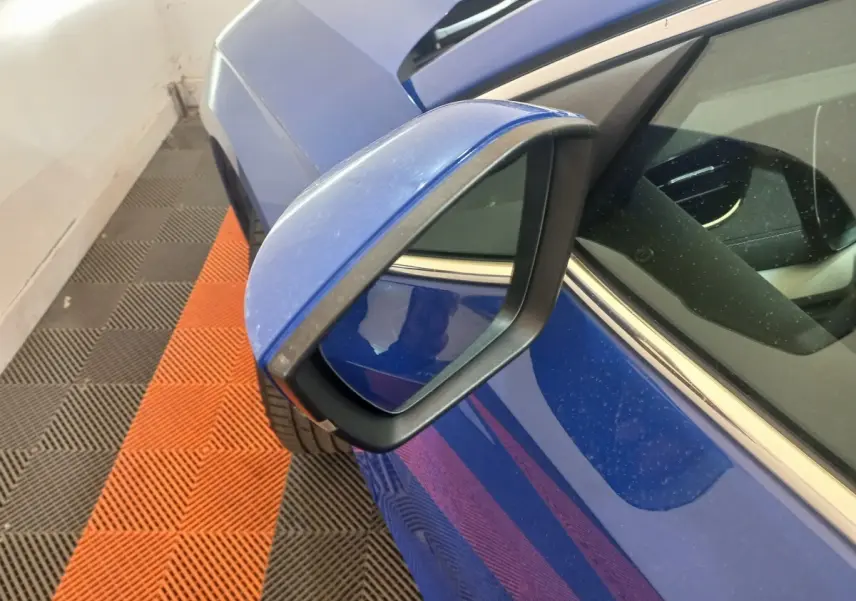 Rétroviseur côté gauche bleu de la Skoda Octavia 1.5 TSI mHEV e-TEC 150 DSG7 Style, vue rapprochée en angle.