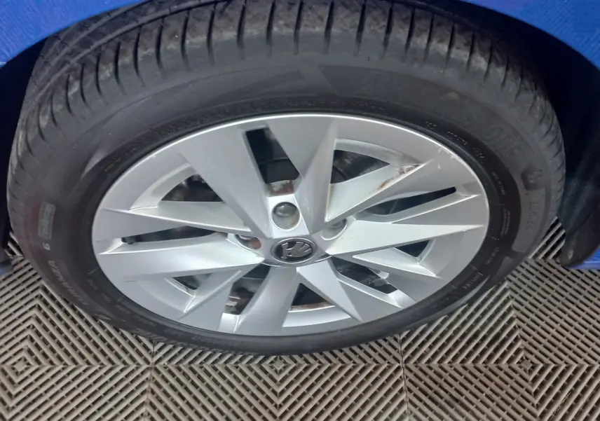 Gros plan sur la roue avant gauche d’une Skoda Octavia bleue, jante alliage argentée à 10 branches.