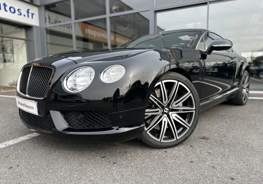 Bentley Continental GT 4.0 V8 Mulliner noire vue en 3/4 avant mettant en valeur ses phares ronds et jantes distinctives.