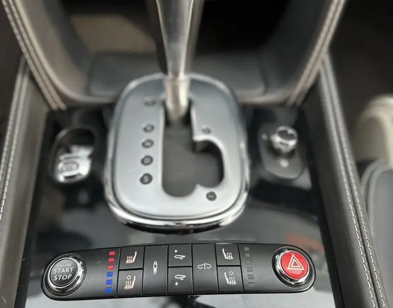 Gros plan sur la console centrale noire de la Bentley Continental GT 4.0 V8 Mulliner 2013 avec levier de vitesse automatique et commandes intégrées.