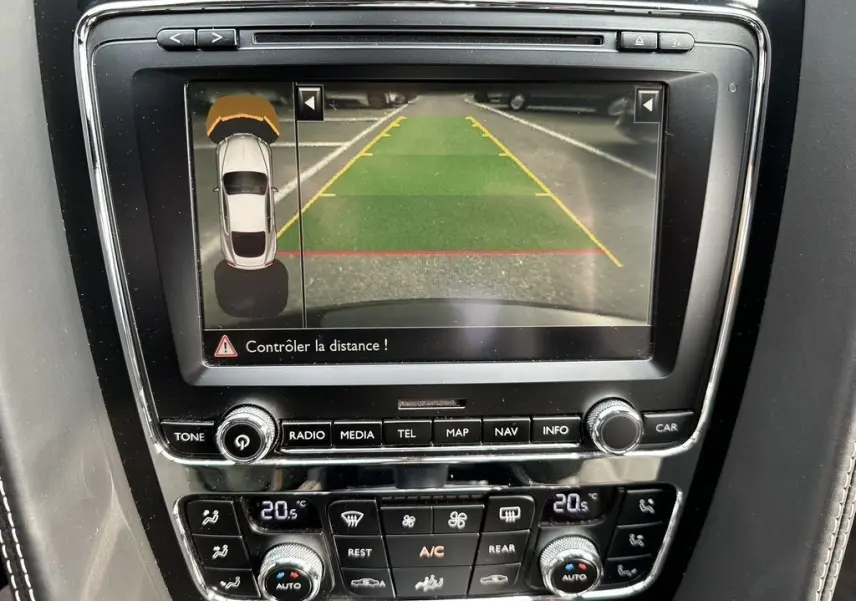 Écran de la console centrale montrant la caméra de recul et les commandes climatisation d'une Bentley Continental GT noire Mulliner 2013.