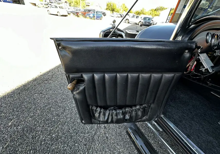 Porte côté gauche en cuir noir matelassé du Ford T Hot Rod V8 1923, avec poignée en bois visible.