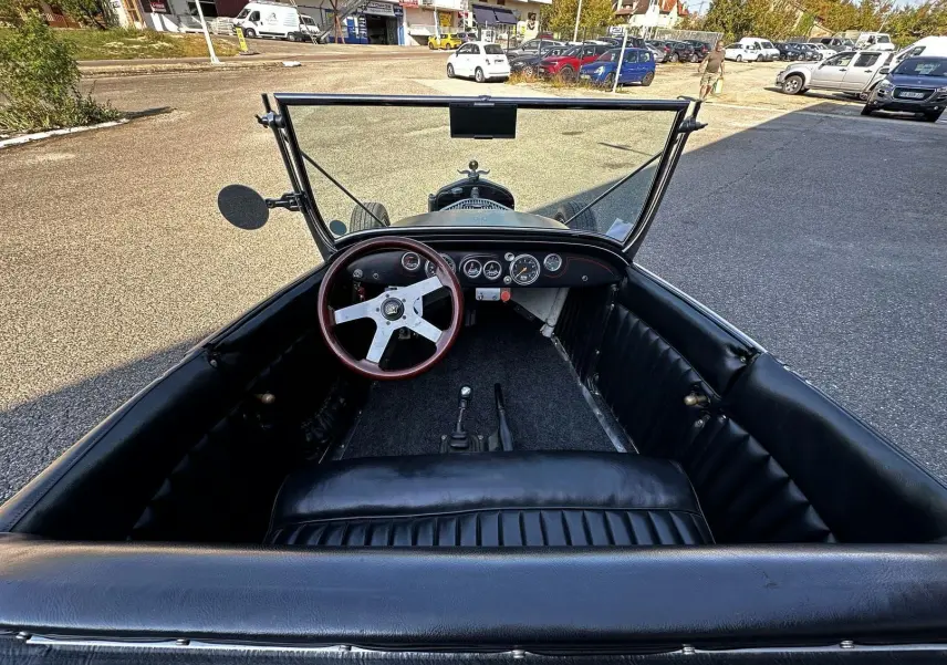 Vue intérieure avant du Ford T Hot Rod 1923 noir, volant bois GT et tableau de bord avec compteurs ronds.