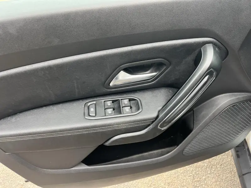 Détail de la porte côté conducteur noire du Dacia Duster 2019 avec commandes des vitres et poignée intégrée.