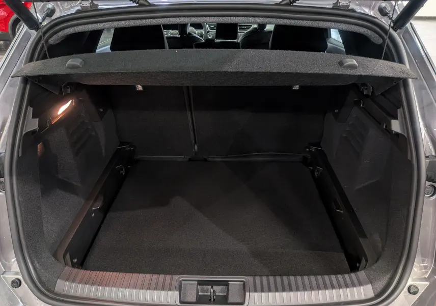 Coffre ouvert du Renault Symbioz gris Cassiopé, vue arrière montrant l'espace de chargement vide et l'éclairage intérieur.