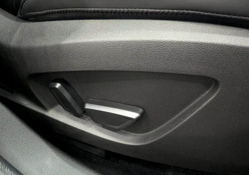 Gros plan sur les commandes de réglage électrique du siège avant en cuir noir du Renault Symbioz hybride 2025.