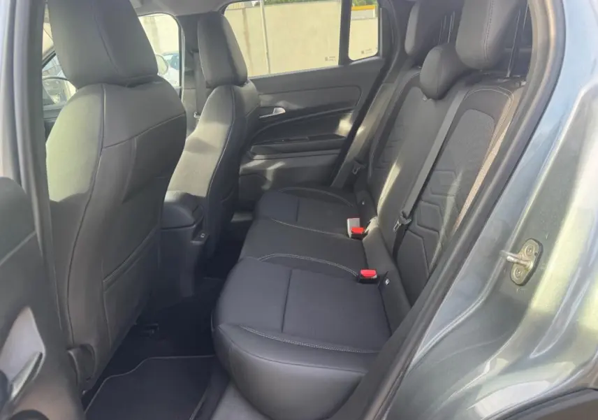 Vue intérieure côté droit des sièges arrière noirs du Jeep Avenger gris 2025, avec ceintures et appuie-têtes visibles.