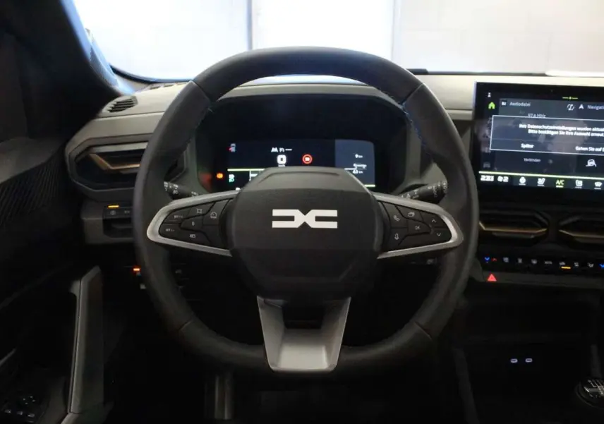 Vue centrée sur le volant cuir noir du Dacia Bigster 2026 avec tableau de bord digital et écran tactile.