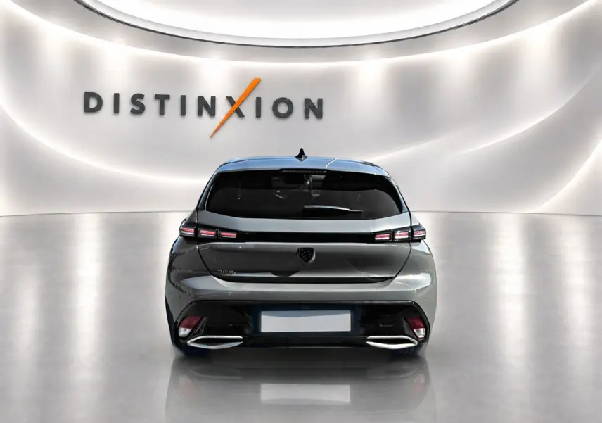 Vue arrière d'une Peugeot 308 gris selenium 2025 dans un showroom avec éclairage moderne et logo Distinxion en arrière-plan.