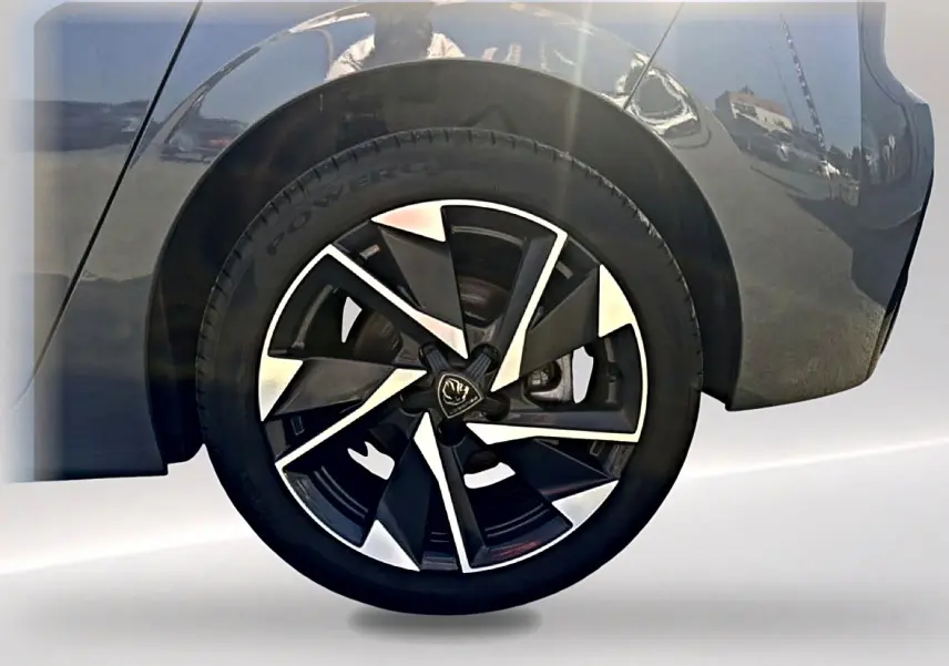 Gros plan sur la roue arrière droite d’une Peugeot 308 gris selenium avec jante alu au design moderne.