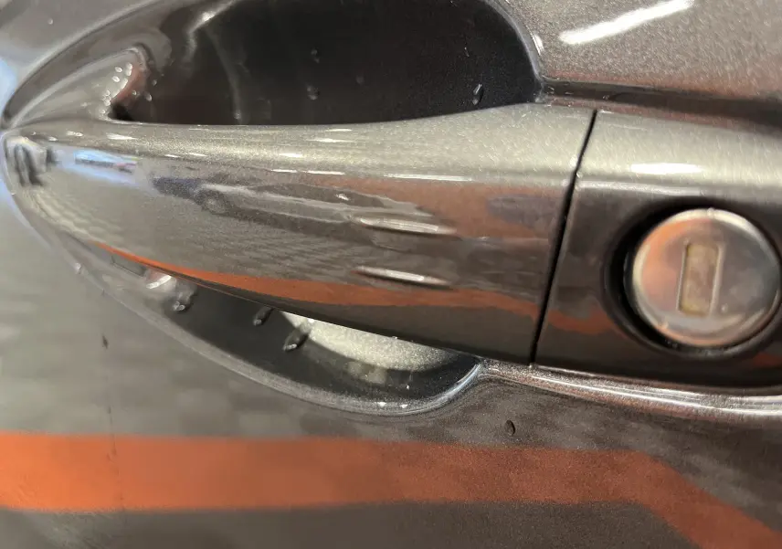 Poignée de porte gris platinium du Peugeot 5008 BlueHDi 130 EAT8 GT 2024 avec serrure intégrée en gros plan.