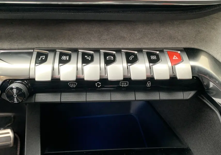 Gros plan sur les boutons de l'aide à la conduite dans l'habitacle noir du Peugeot 5008 GT 2024.
