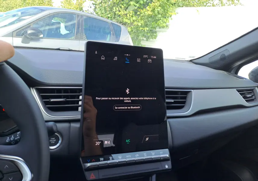 Vue intérieure du tableau de bord du Renault Captur 2025 avec écran tactile central et volant partiel visible.