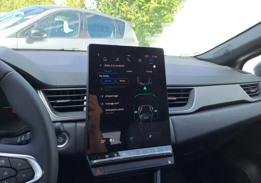 Intérieur du Renault Captur 2025, vue du tableau de bord avec écran tactile central allumé et volant partiel visible.