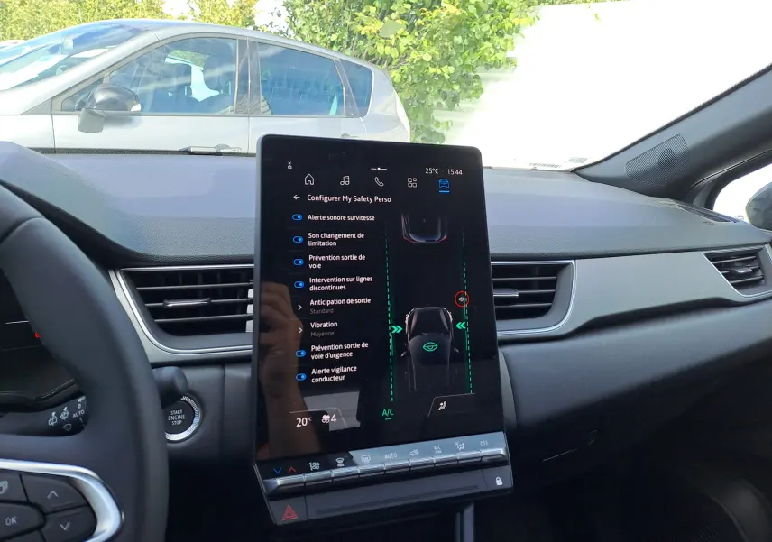Intérieur du Renault Captur 2025, vue centrale du tableau de bord avec écran tactile affichant les aides à la conduite.
