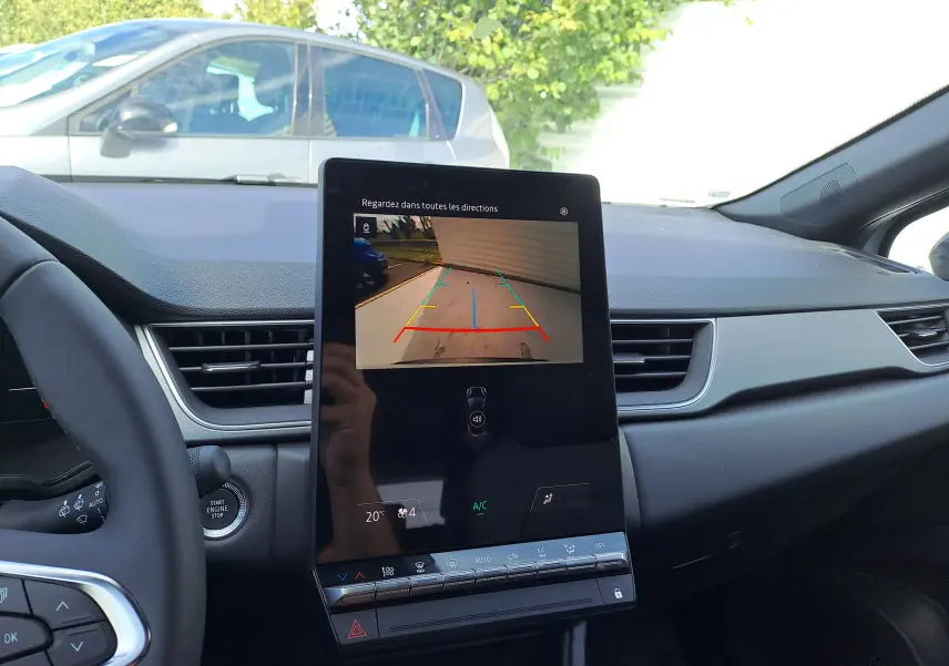 Vue intérieure du tableau de bord du Renault Captur 2025 avec écran tactile affichant la caméra de recul en marche.