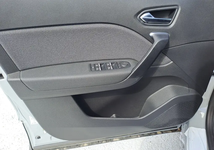 Panneau intérieur côté gauche de la porte avant d'un Renault Captur gris Rafale métal, avec commandes de vitres et poignée noire.