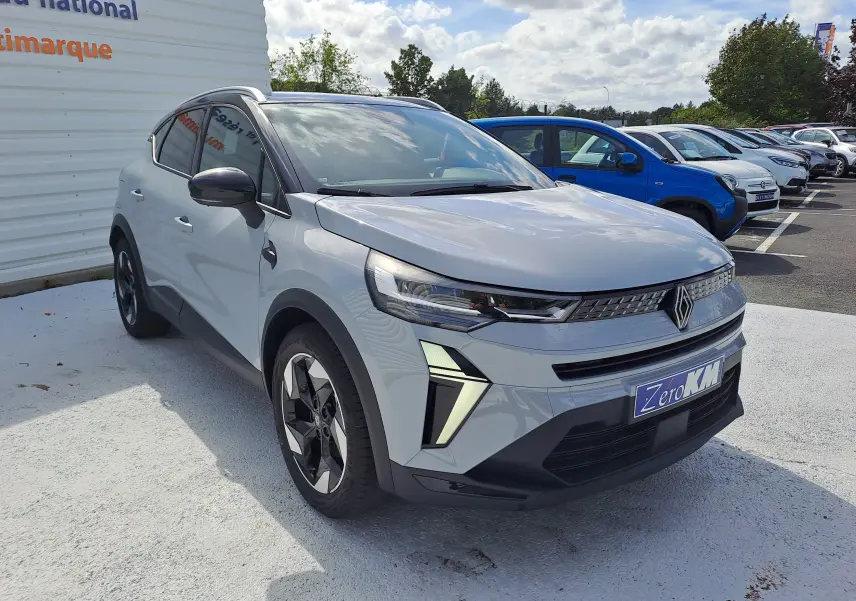 Renault Captur 2025 gris Rafale métal avec toit noir, vue 3/4 avant mettant en valeur ses phares LED et jantes biton.