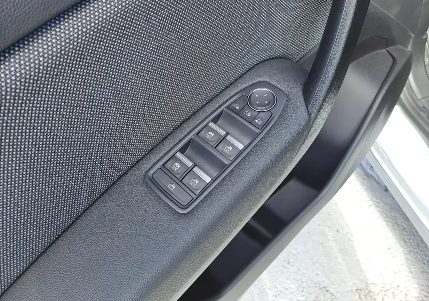 Gros plan sur les commandes des vitres et rétroviseurs côté conducteur du Renault Captur gris Rafale métal 2025.