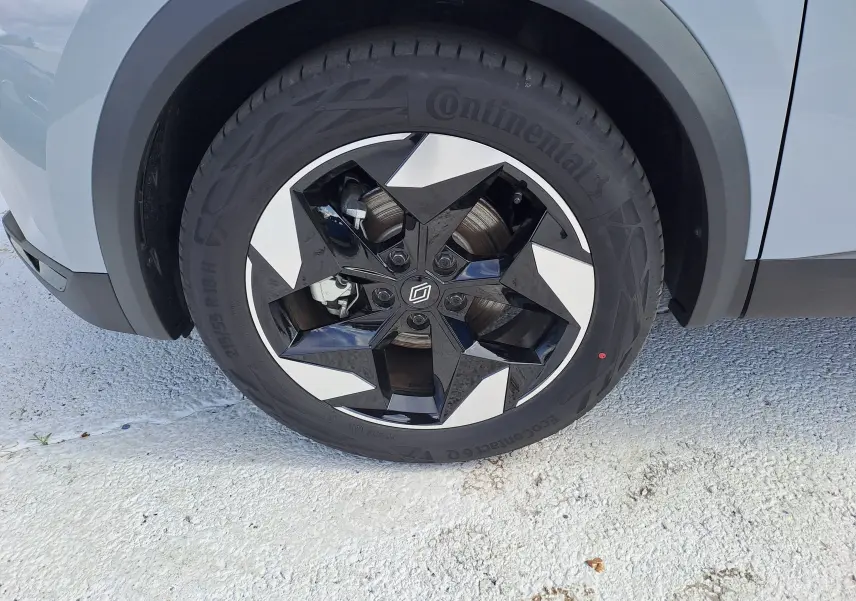 Gros plan sur la roue avant gauche du Renault Captur gris Rafale métal avec jante noire et argentée au design étoilé.