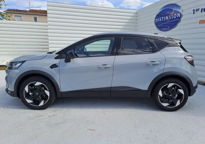 Profil droit du Renault Captur 2025 gris Rafale métal avec toit noir et jantes noires bicolores.