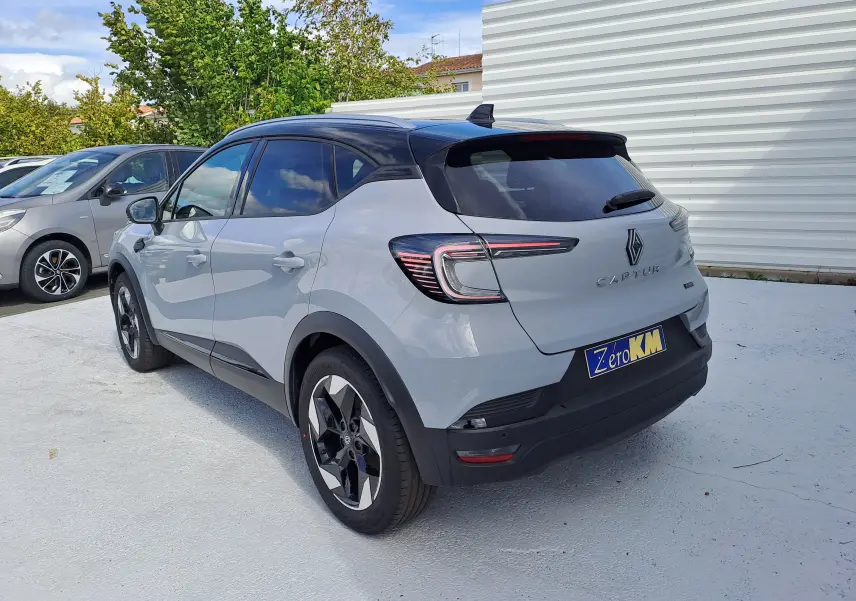 Vue 3/4 arrière droite du Renault Captur 2025 gris Rafale métal avec toit noir et feux arrière LED distinctifs.
