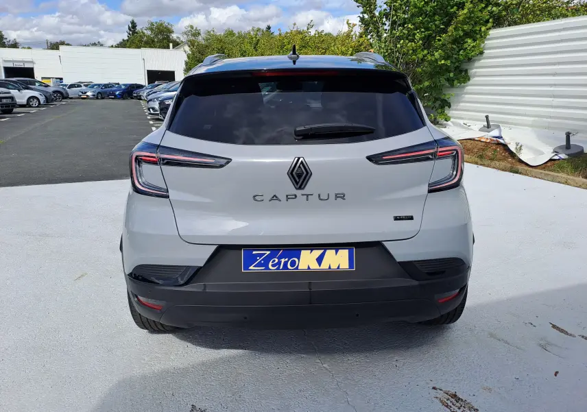 Vue arrière d'un Renault Captur gris Rafale métal avec toit noir, mettant en valeur ses feux LED et son logo central.