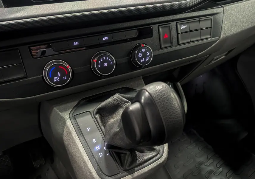 Gros plan sur le levier de vitesses automatique et les commandes de climatisation du Volkswagen Transporter 6.1 Van blanc.