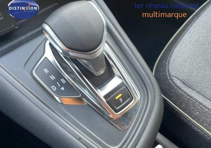 Le levier de vitesses automatique noir et chrome de la Renault Symbioz E-Tech hybride, avec siège tissu gris à côté.