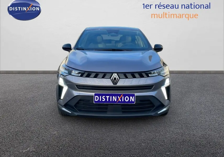 Vue frontale d'une Renault SYMBIOZ E-TECH hybride gris cassiopée métal avec feux LED allumés sur fond neutre.