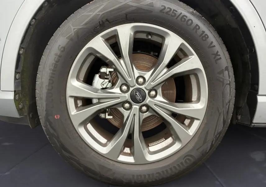 Gros plan sur la roue avant gauche grise du Ford Kuga 2024 avec jante alliage et pneu Continental EcoContact 6.