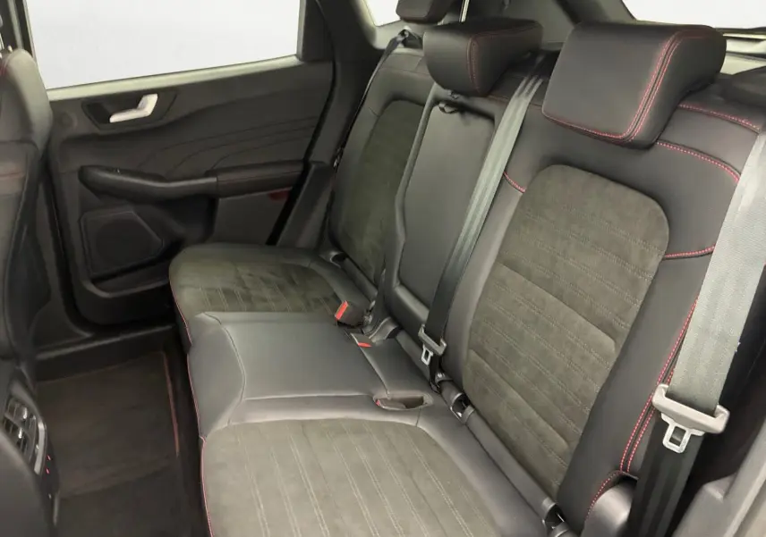 Vue intérieure des sièges arrière en cuir noir avec surpiqûres rouges du Ford Kuga 2024, version hybride.