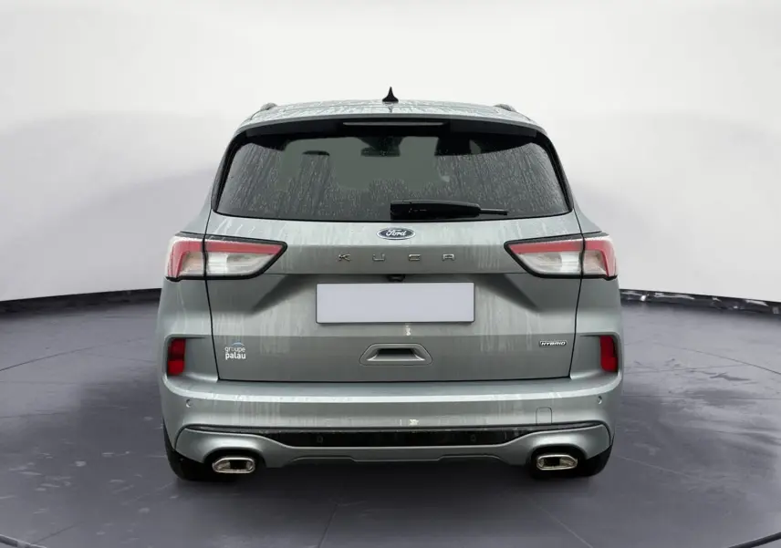 Vue arrière d'un Ford Kuga gris 2024 hybride avec double sortie d'échappement et logo KUGA bien visible.