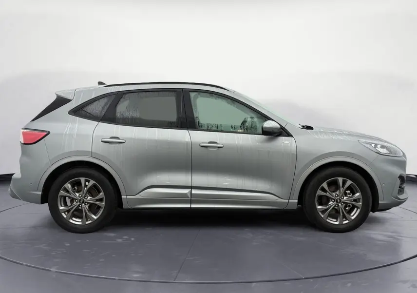 Profil droit d’un Ford Kuga gris 2024 hybride essence, avec jantes alliage et lignes dynamiques ST-Line X.
