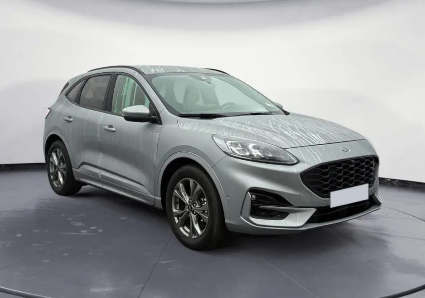 Vue 3/4 avant droit d'un Ford Kuga 2024 gris avec calandre noire et jantes alliage, version hybride essence ST-Line X.