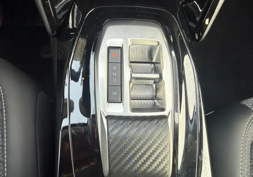 Gros plan sur la console centrale noire brillante avec sélecteur de vitesses automatique de la Peugeot 208 Hybrid 110.