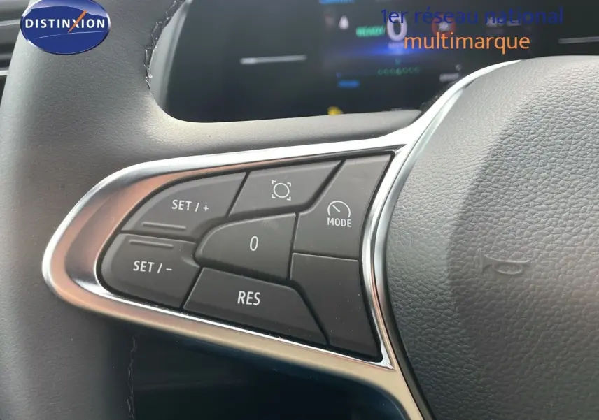 Gros plan sur les commandes au volant du Renault Captur 2025, finition gris cassiopée métal avec toit noir.