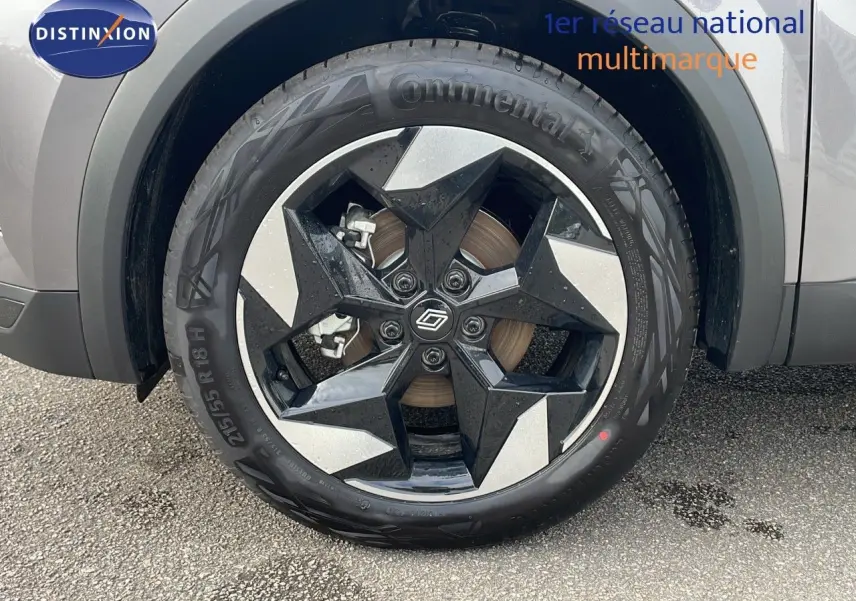 Gros plan sur la roue avant gauche du Renault Captur gris Cassiopée métal avec jante noire et argentée design étoile.
