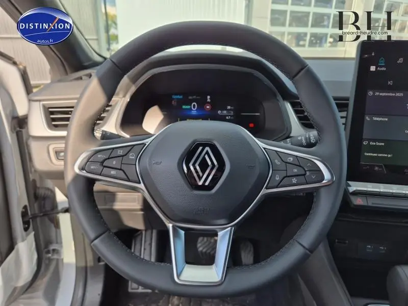 Vue rapprochée du volant multifonction noir du Renault Captur 2025 avec tableau de bord digital et écran tactile.