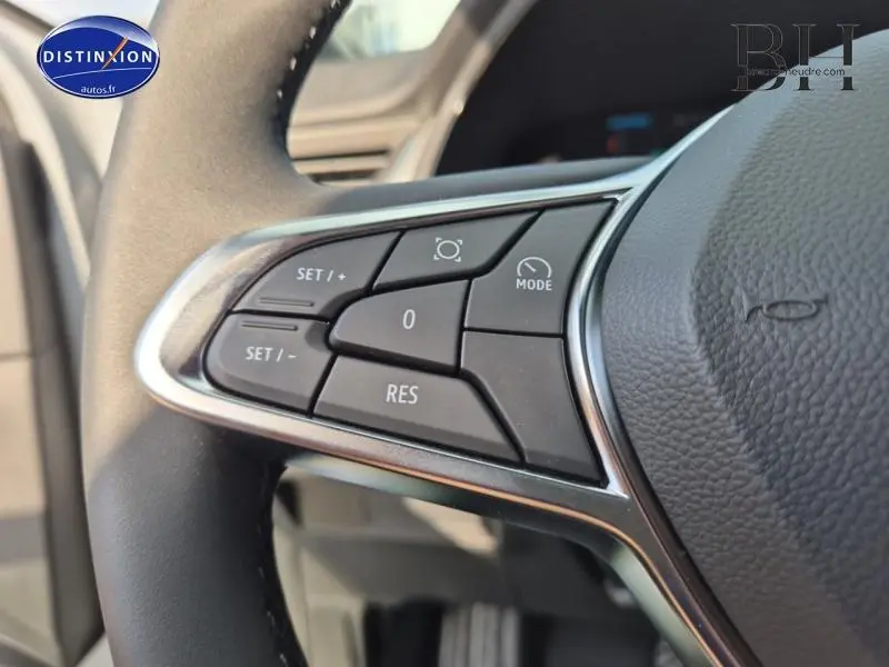 Gros plan sur les commandes multifonctions du volant noir du Renault Captur 2025 hybride gris Rafale/Noir Etoilé.