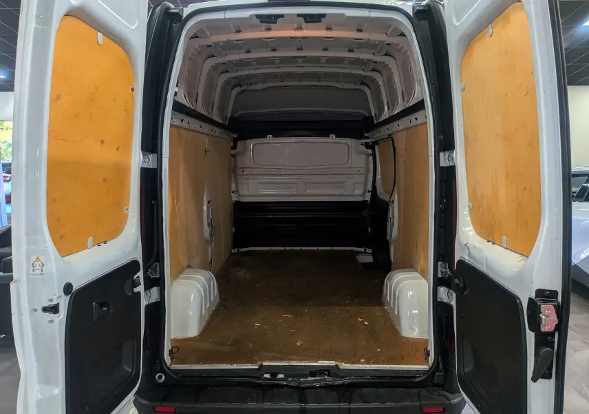 Vue arrière ouverte du Renault Trafic Fourgon blanc glacier L2H2 montrant l'espace de chargement avec parois en bois.