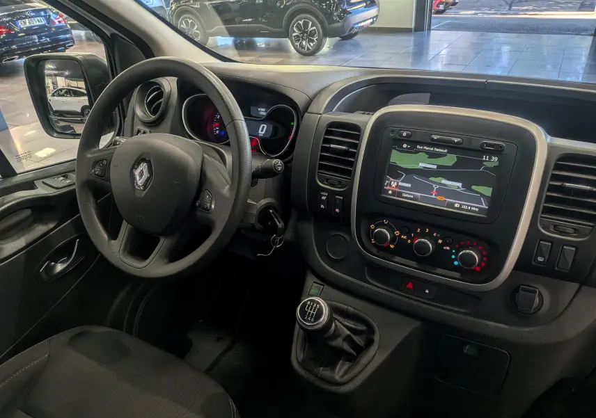 Intérieur du Renault Trafic Fourgon L2H2 2021, vue du poste de conduite avec tableau de bord et écran GPS intégré.