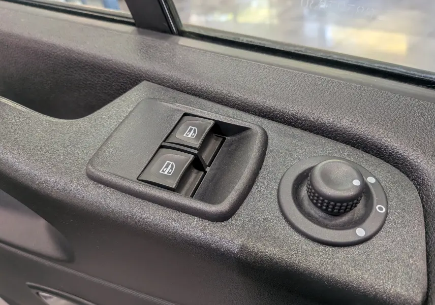 Commande des vitres électriques et réglage des rétroviseurs sur la portière côté conducteur d'un Renault Trafic blanc.