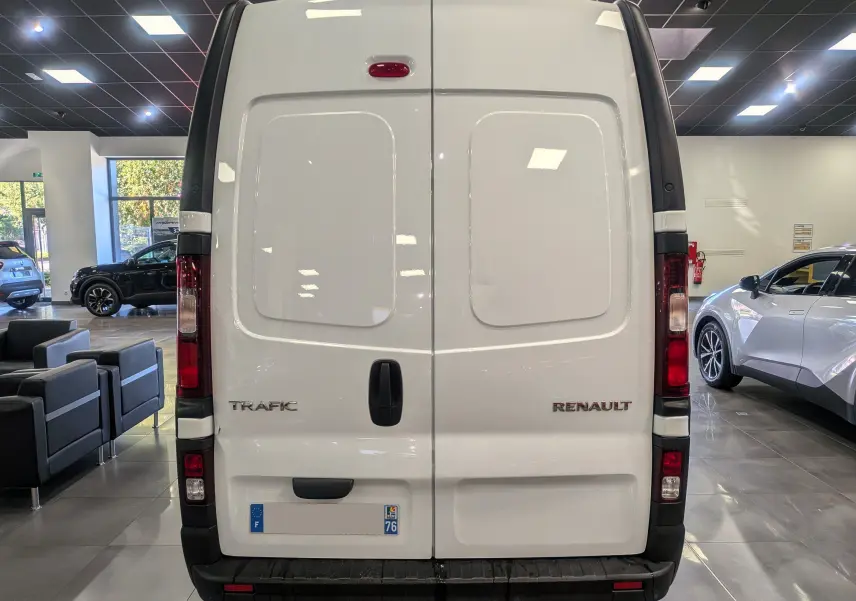 Vue arrière du Renault Trafic Fourgon blanc Glacier L2H2, portes battantes fermées en showroom lumineux.