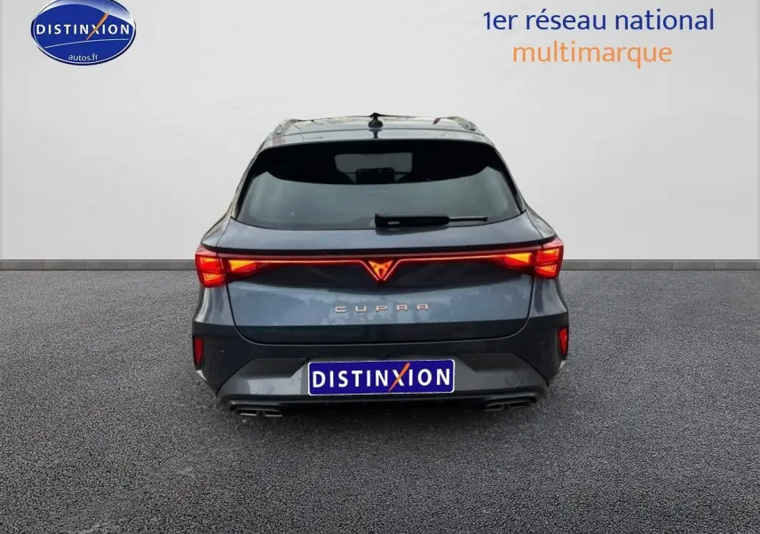 Vue arrière d'une CUPRA Leon ST 2025 gris magnétique avec feux arrière LED allumés et double sortie d'échappement.