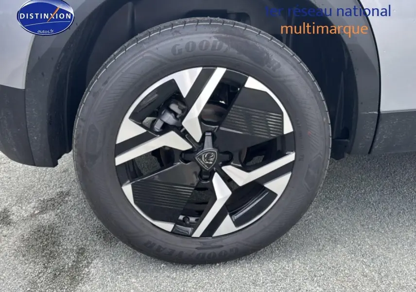 Gros plan sur la roue avant gauche avec jante alu bicolore du Peugeot 2008 gris artense 2025.