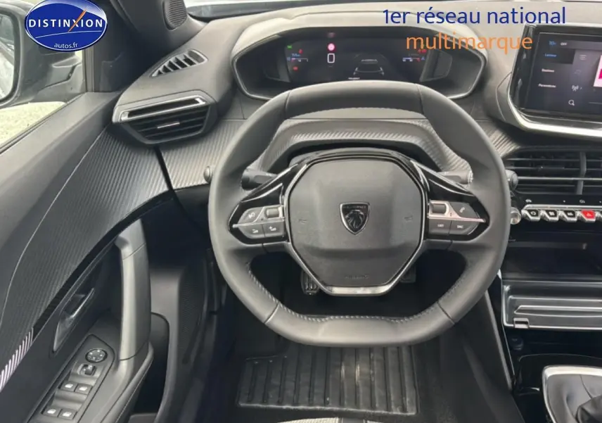 Vue intérieure centrée sur le volant multifonction de la Peugeot 2008 gris artense avec tableau de bord digital et écran tactile.