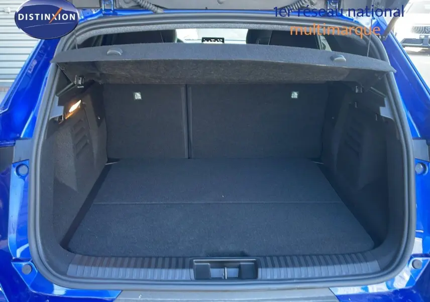 Coffre ouvert vu de l'arrière d'une Renault Symbioz bleu iron metal, montrant un espace de chargement propre et spacieux.