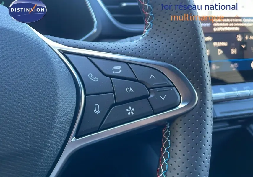 Gros plan sur les commandes gauche du volant en cuir perforé avec surpiqûres tricolores du Renault Symbioz bleu iron metal.